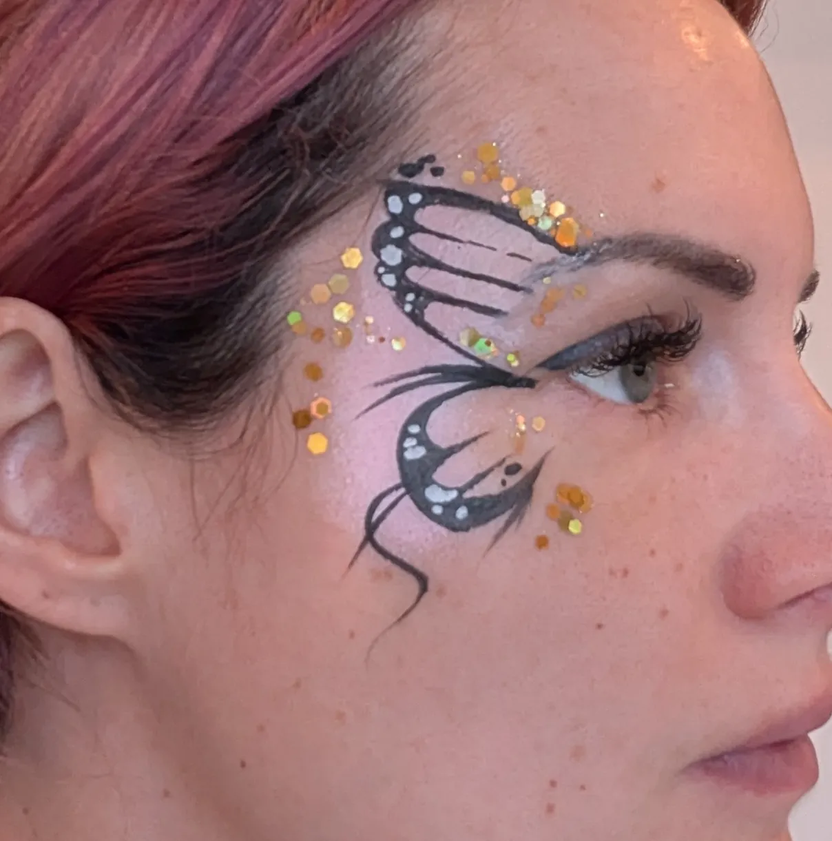 Maquillage artistique arc-en-ciel et fleurs roses autour de l&rsquo;&oelig;il